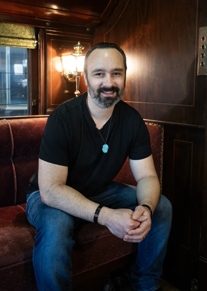 Michael Streck seated on a red velvet bench